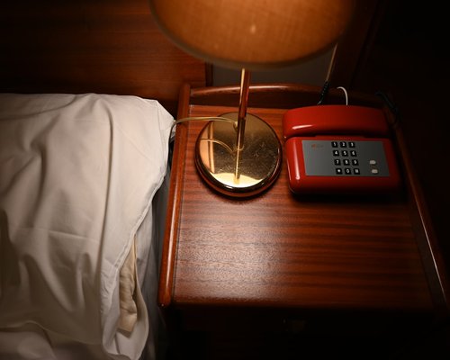 An alarm clock on a bedside table without a phone